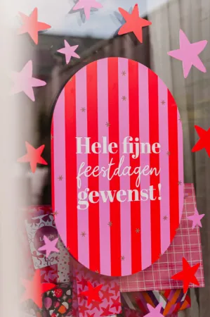 Decoratieve raamstickers rode en roze sterren voor feestelijke sfeer.