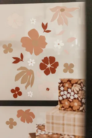 Raamsticker met losse bloemen in wit- en mokkakleuren voor zachte look.