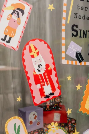 Raamsticker met vrolijke Sinterklaas- en Piet-illustraties.