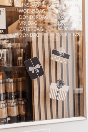 Feestelijke raamsticker met zwarte en gouden cadeautjes voor speciale gelegenheden.